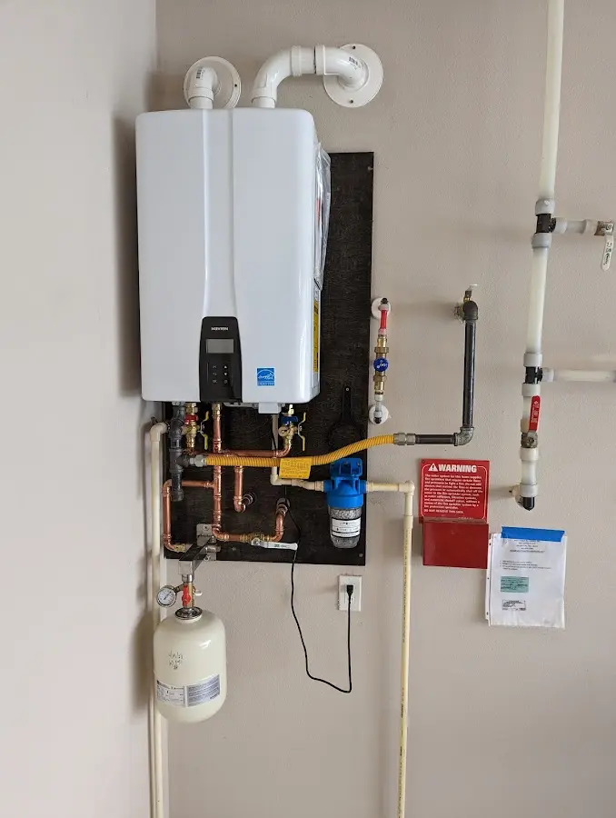 Professional plumber installing copper piping in a New Baltimore home